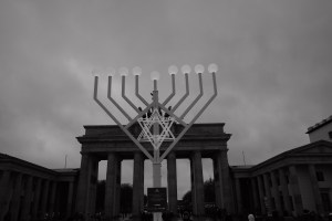 Símbolo da Menorá com Portão de Brandemburgo ao fundo  